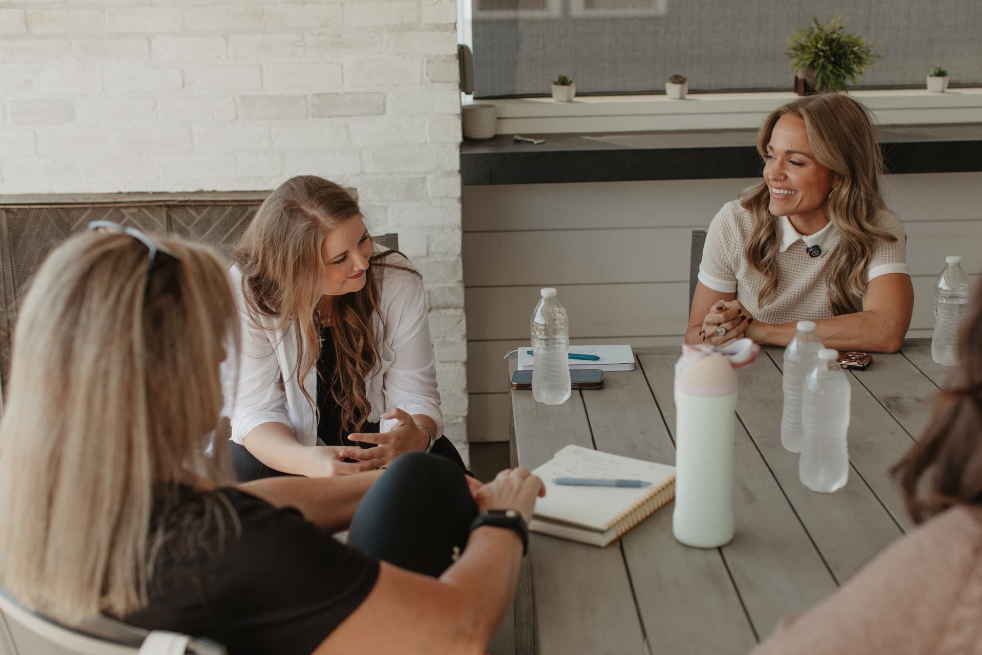 Women in conversation around an outdoor table during the 2026 Newport Beach retreat