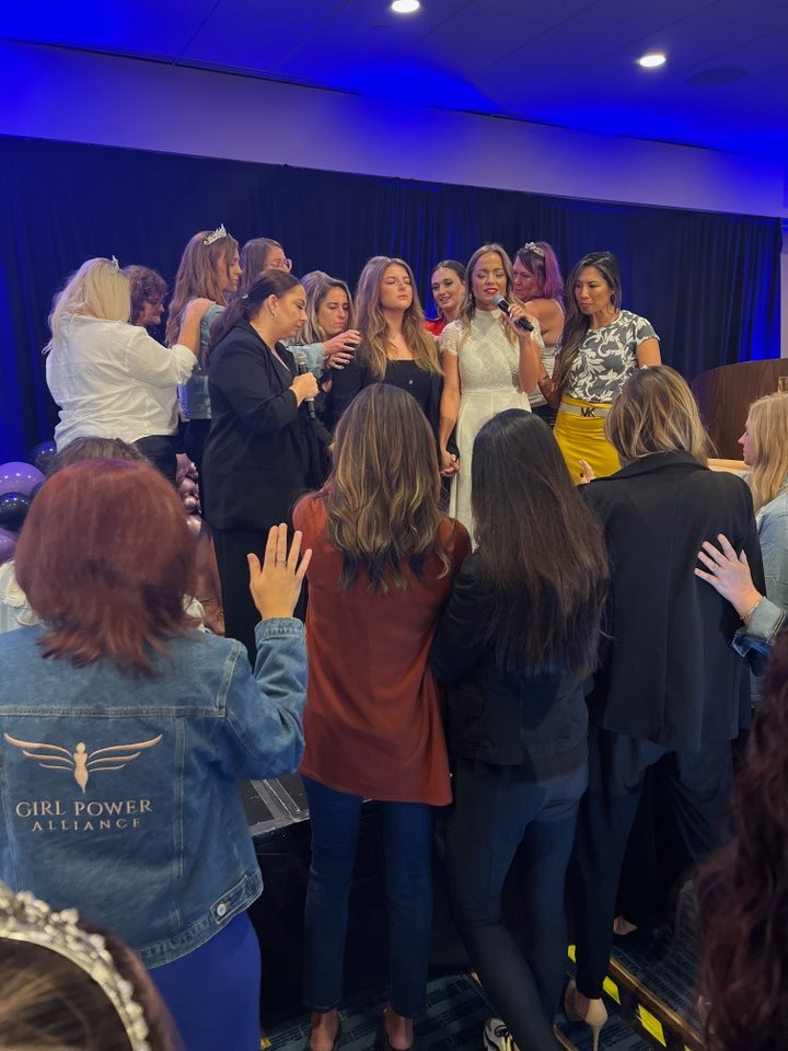 Women gathered together in prayer at an Aligned & Assigned event